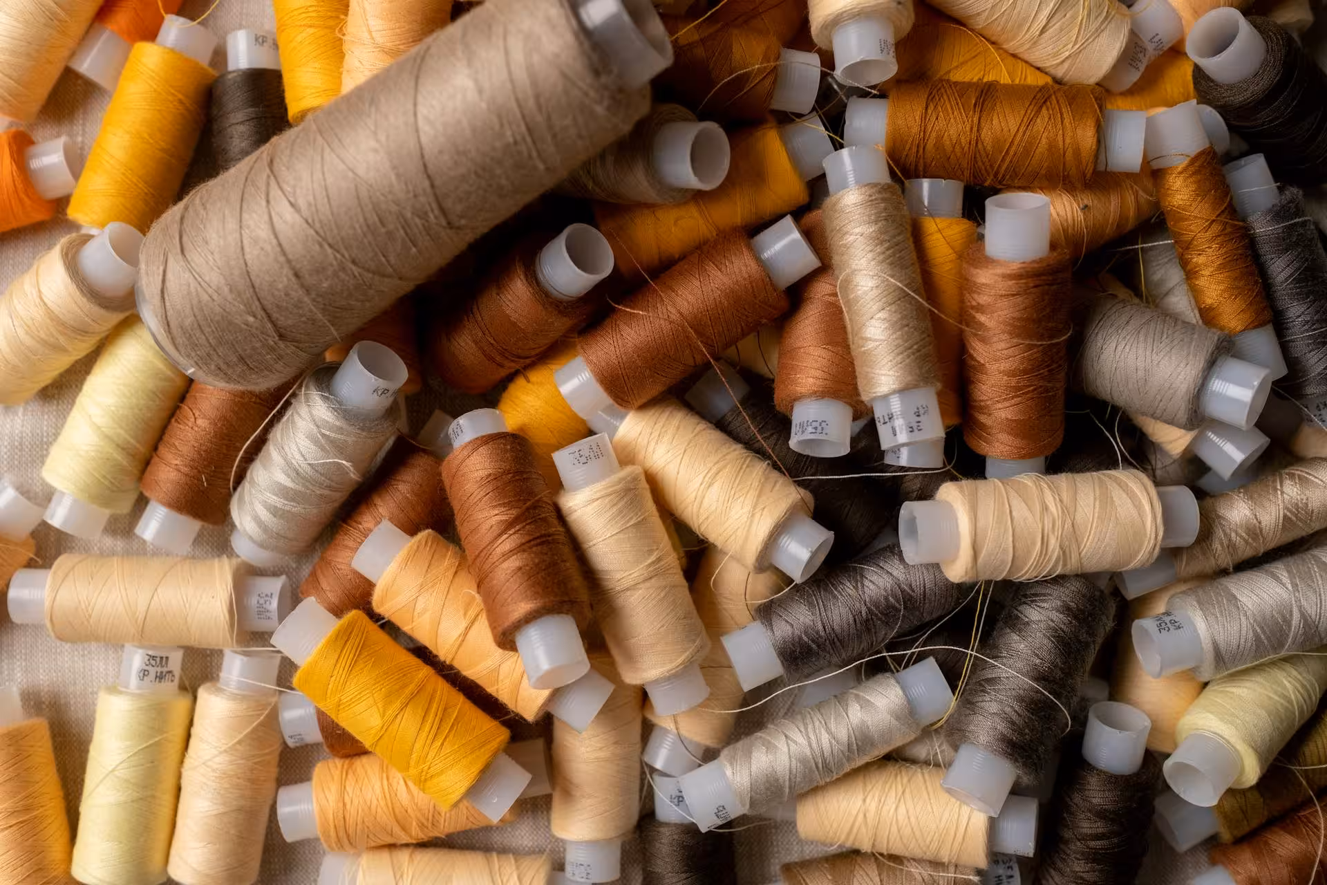 Warm-toned textile thread spools arranged on fabric